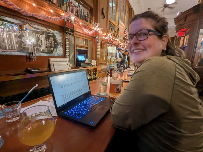 person on computer in a bar